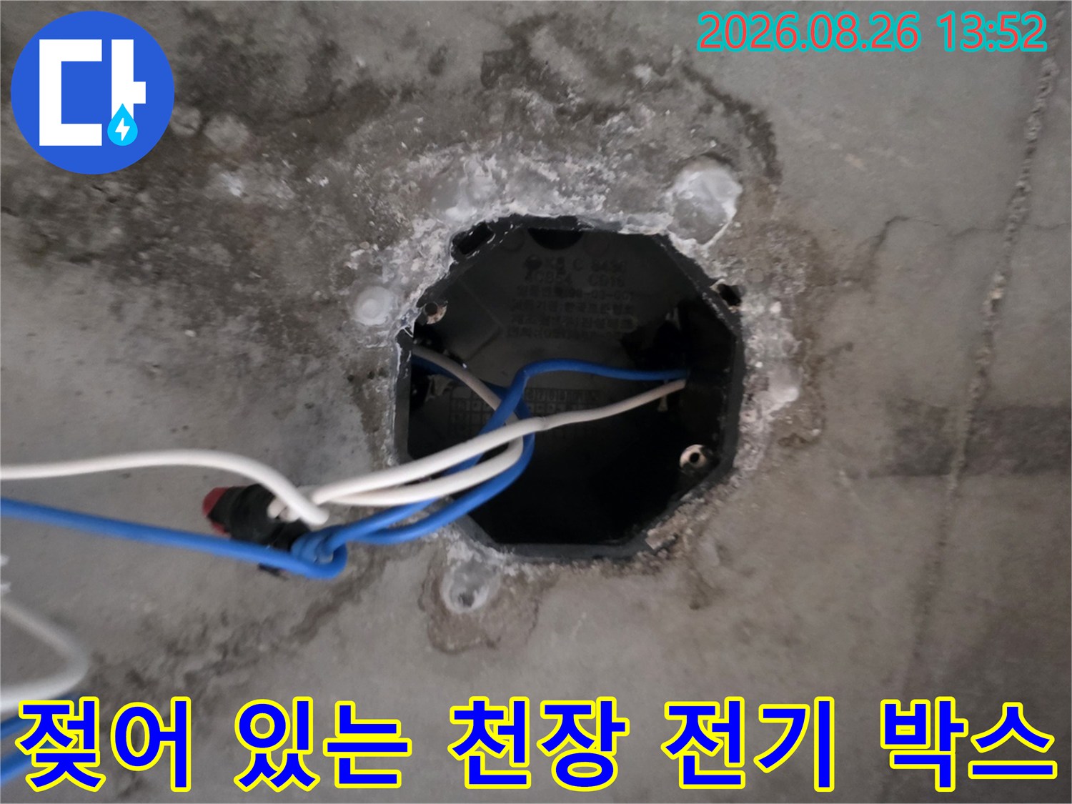 천장 내부의 전선과 함께 습기에 노출된 전기 박스를 촬영한 이미지입니다.