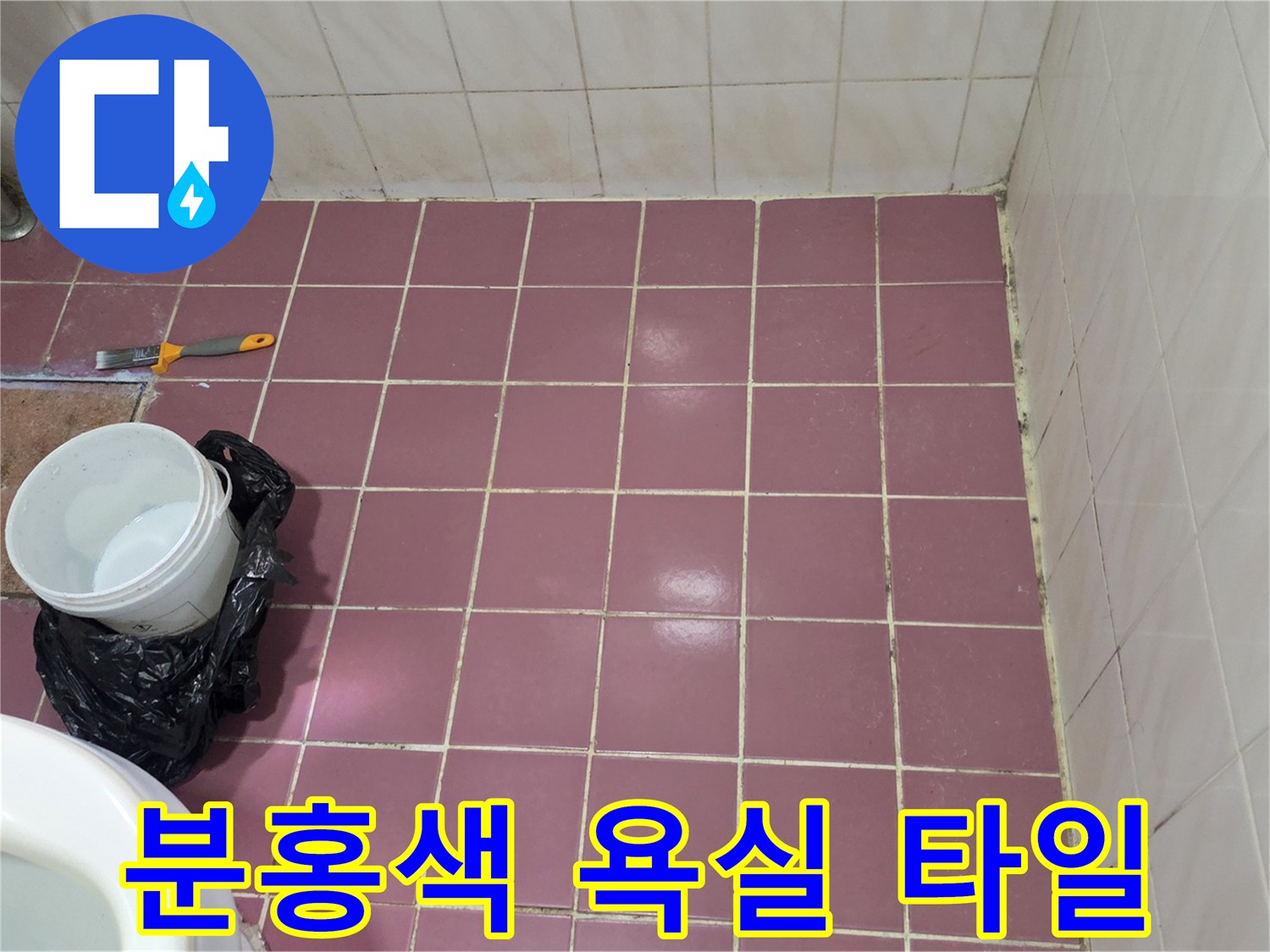 분홍색 타일 바닥에 놓인 작업용 도구와 양동이