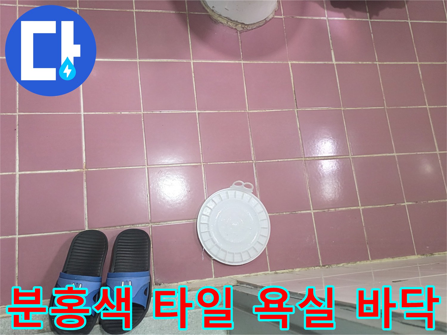 분홍색 타일로 마감된 화장실 바닥과 배수구 덮개 모습