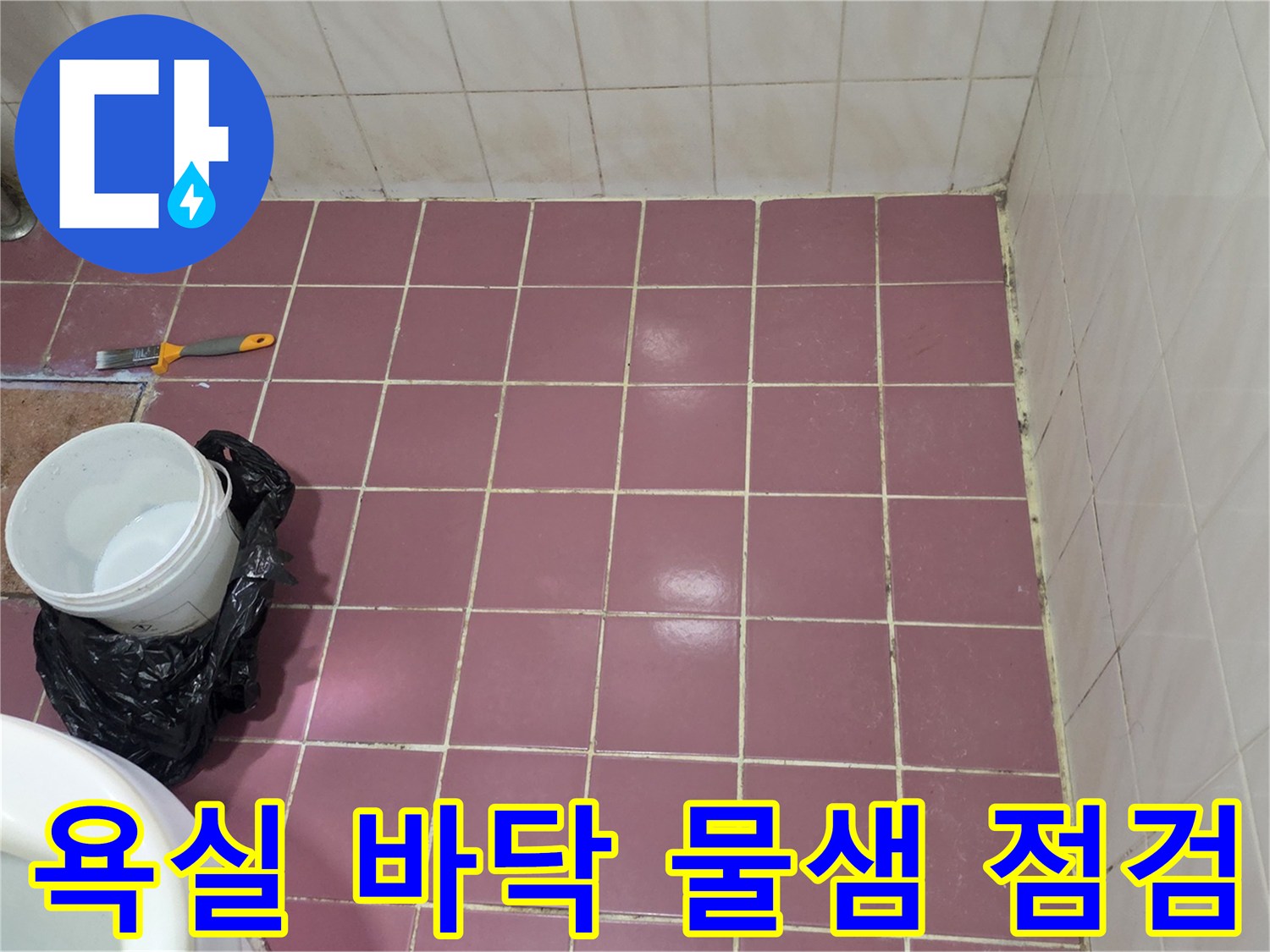 작업 도구가 놓여 있는 분홍색 타일 바닥의 근접 사진입니다.