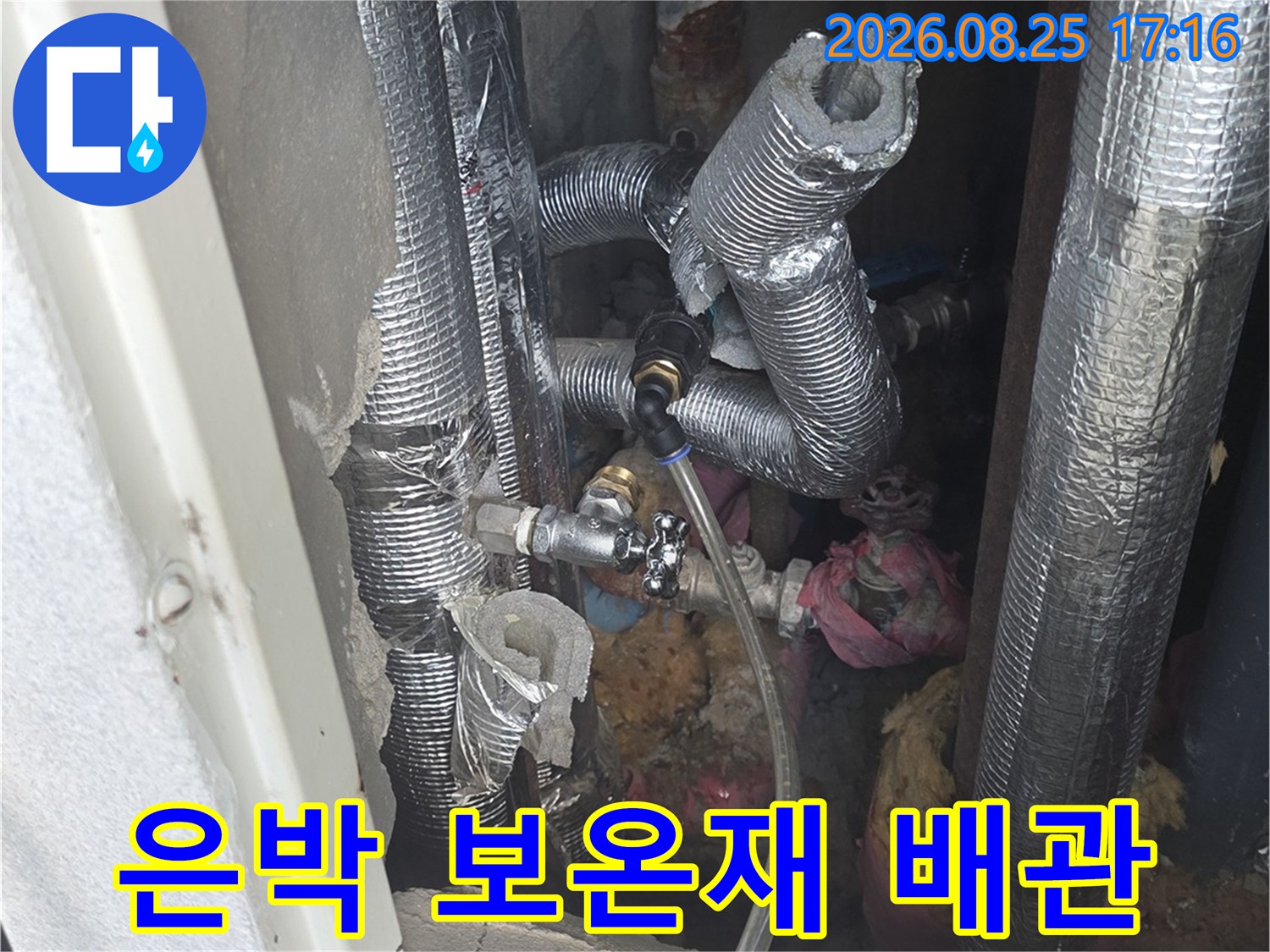 보온재로 감싸진 수도 배관과 밸브의 모습입니다.