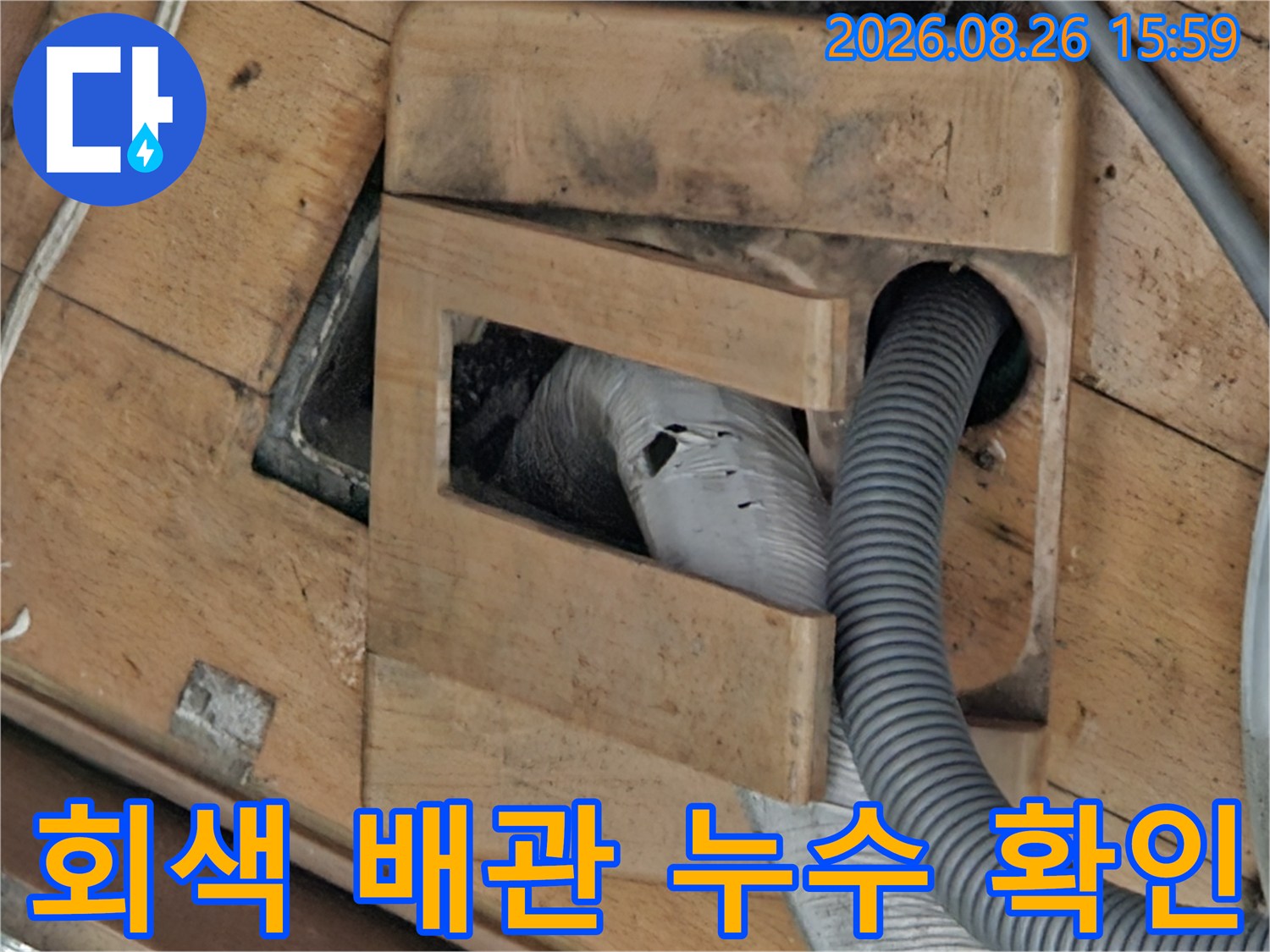 회색 주름 배관 주변의 습기와 틈새를 점검하는 중입니다.