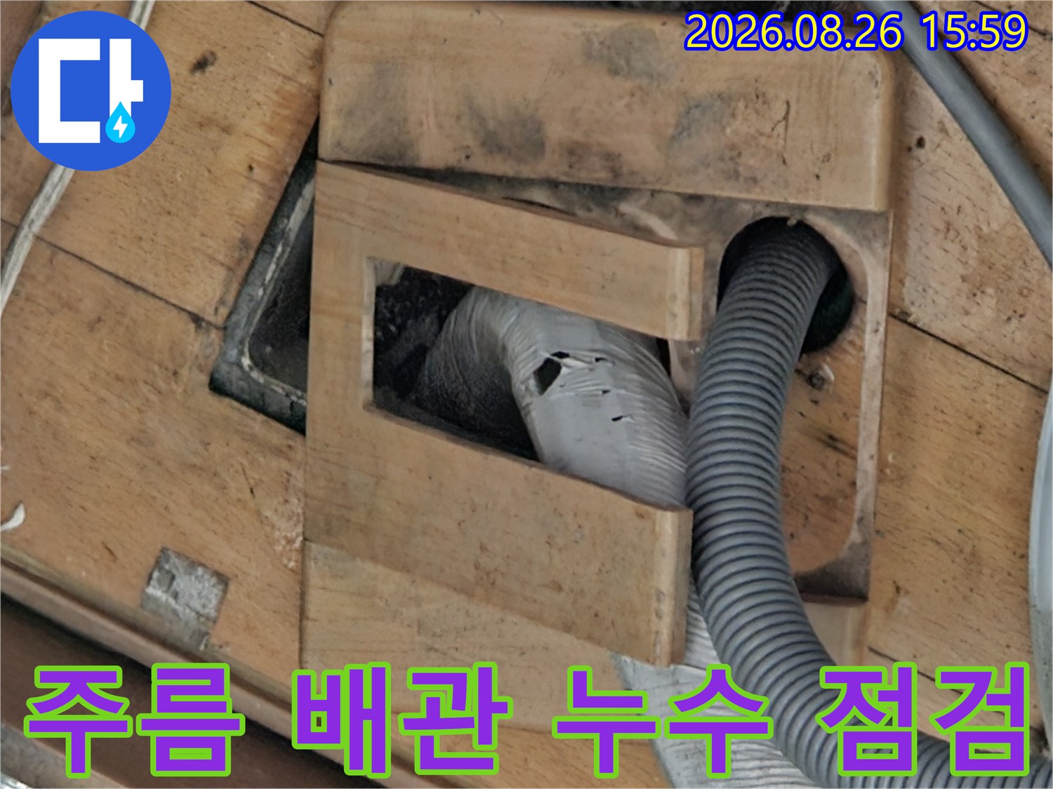 회색 주름관과 나무 마감재 사이의 틈새 확인