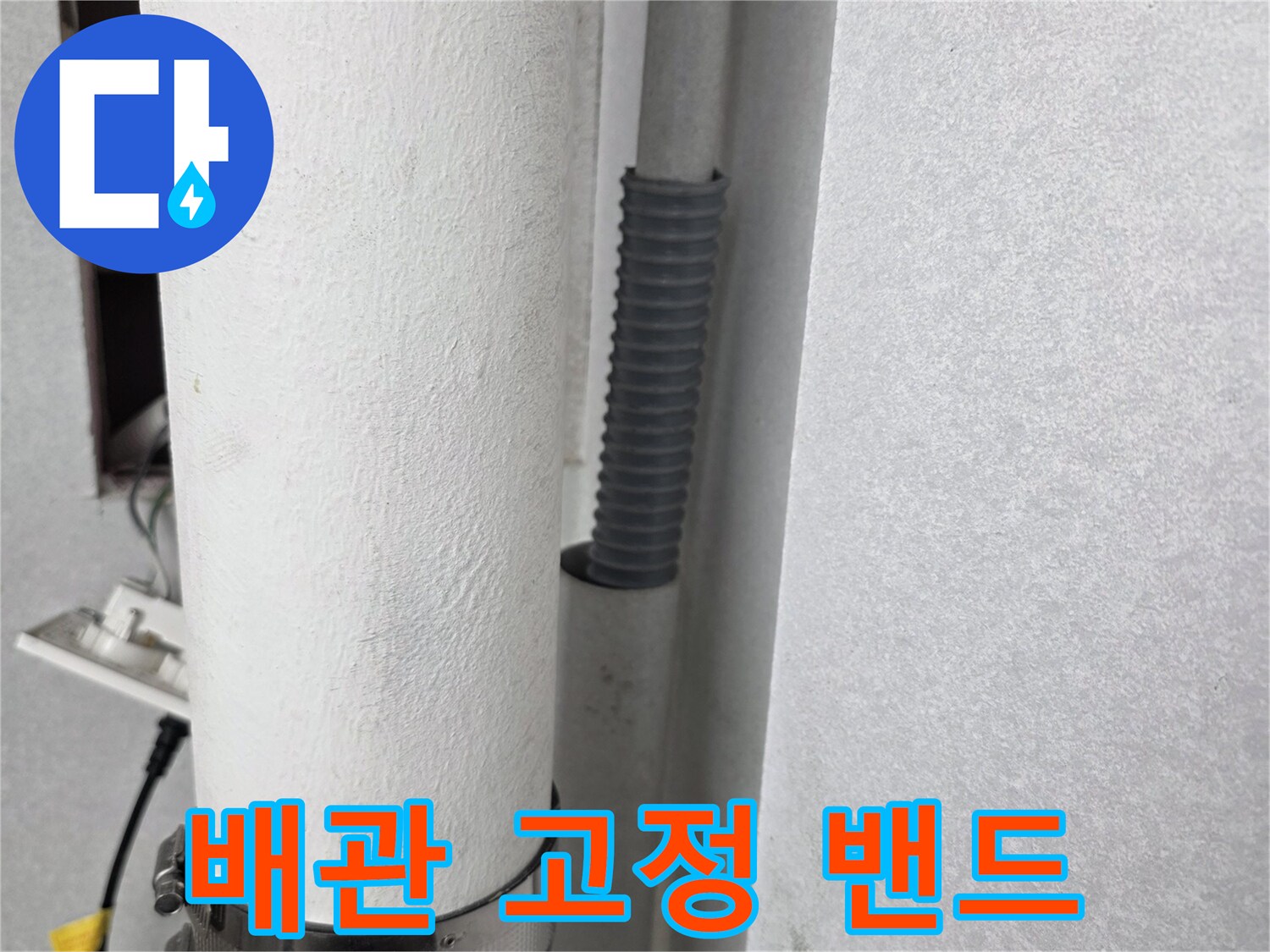 우수관 하단에 설치된-금속 밴드와 연결 배관
