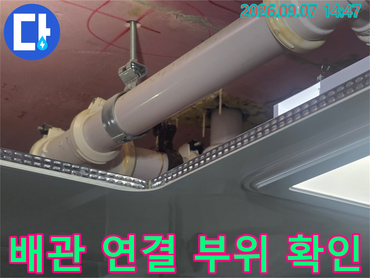천장 내부의 굵은 배관과 연결 커플링 부분을 근접 촬영한 사진입니다.