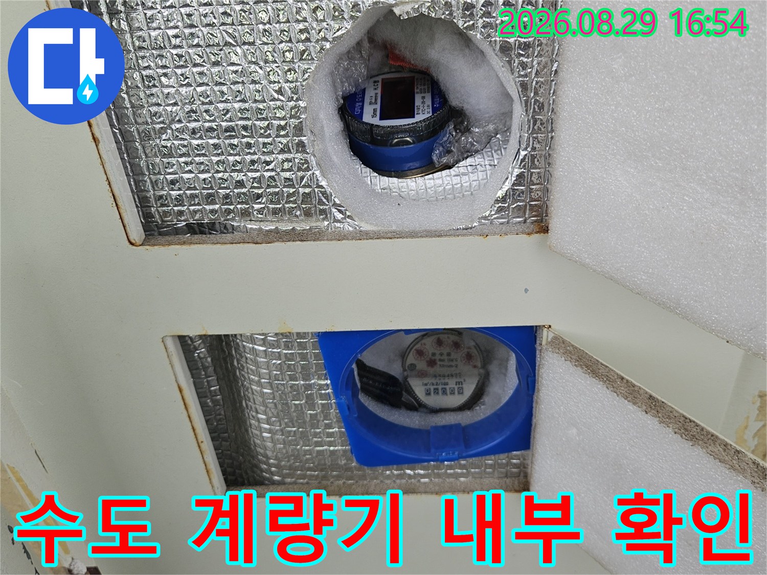 계량기함을 통해 본-은박 단열재로 마감된 배관 연결 부위