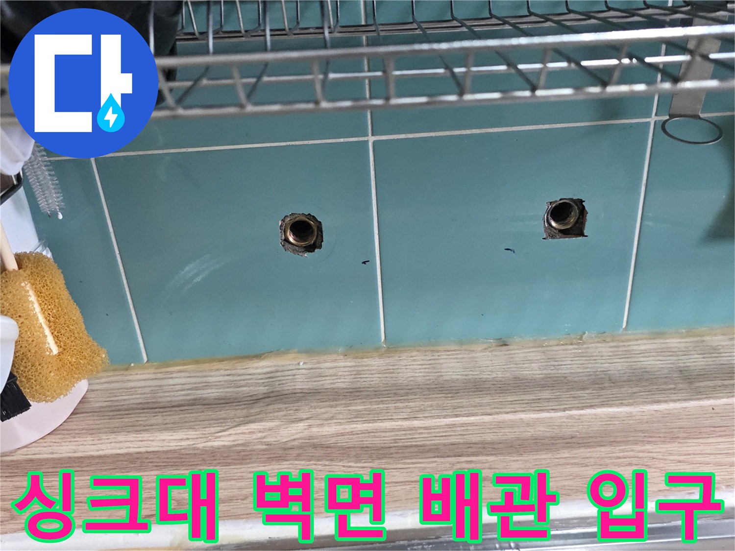 싱크대 아래 타일벽에 노출된 수도 배관 연결부