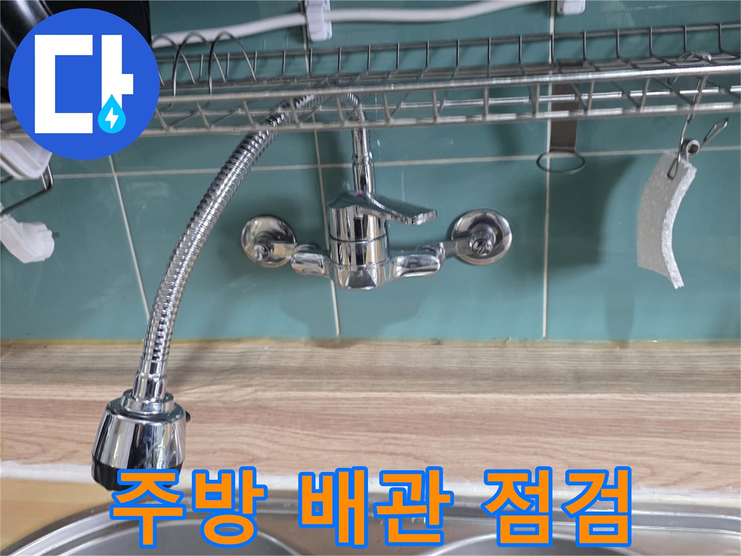 싱크대 하단 벽면 수도 밸브와 연결 호스 근접 촬영