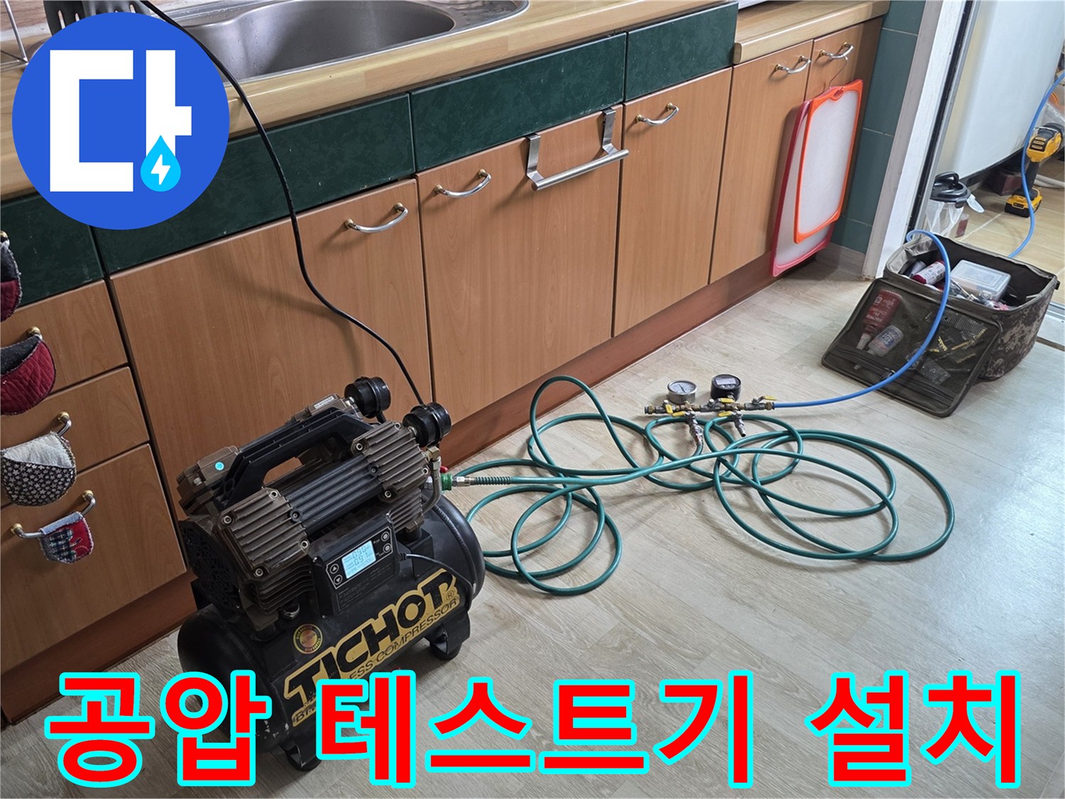 싱크대 하부 배관 압력 측정을 위해 배치된 공압 장비와 호스