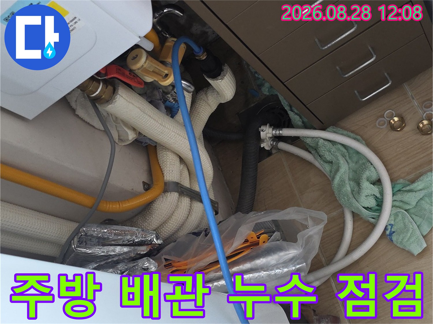 싱크대 하부장 내부의 노란색 보일러 배관과 급수 호스 연결 부위 확인