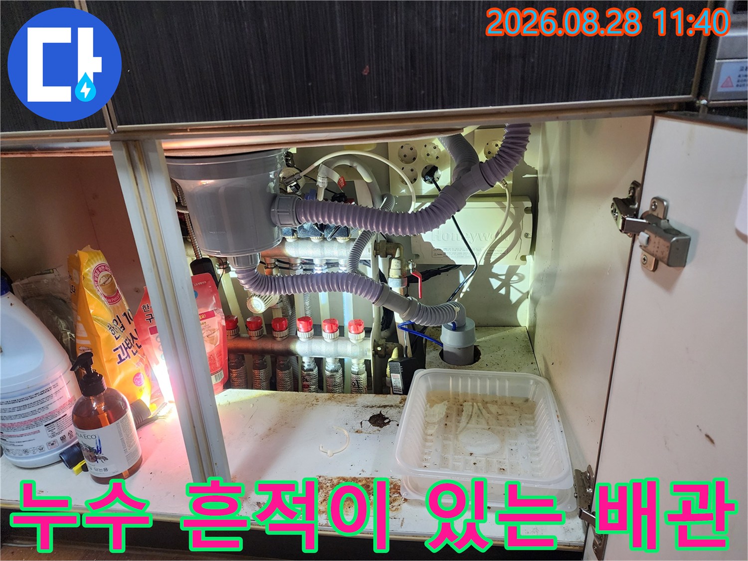 물기가 스며든 싱크대 하부 바닥과 복잡하게 연결된 배관들