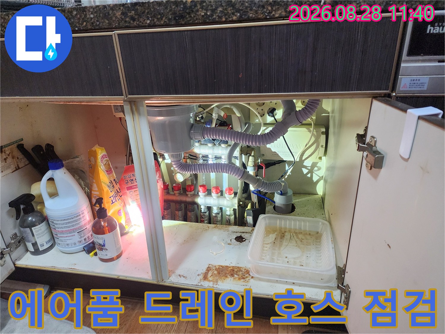 싱크대 하부장 안쪽의 에어컨 배수 호스와 주방 배수관 상태