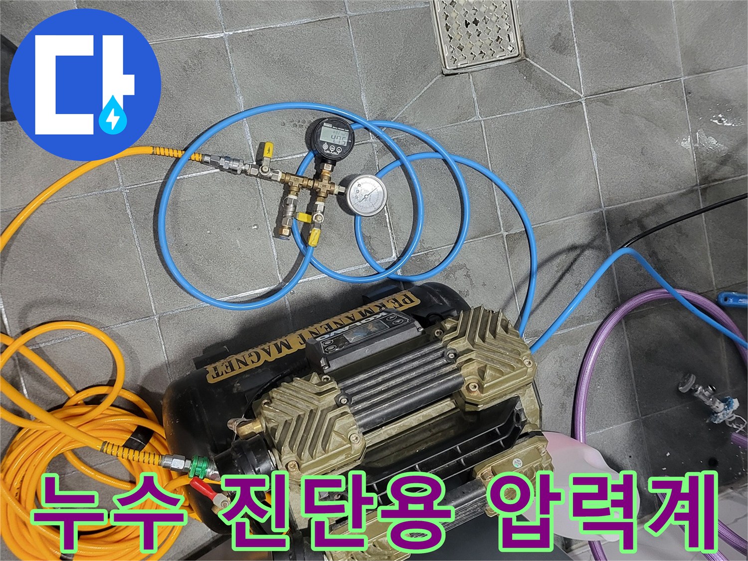 타일 바닥에 설치된 배관 점검용 게이지와 노란색 에어 호스