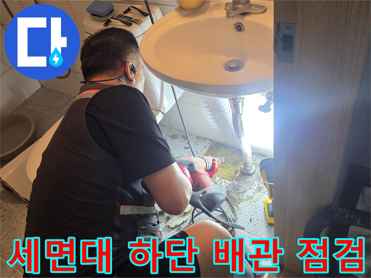 세면대-밑부분의-배관-연결부를-조사하는-엔지니어의-모습