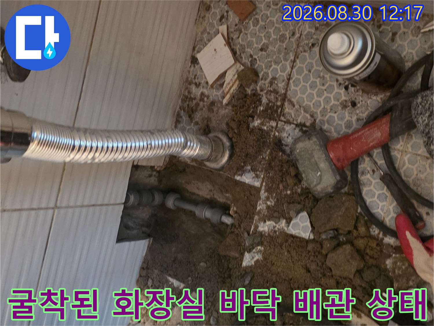 욕실 타일 제거 후 드러난 흙과 노출된 배관 연결 부위의 모습
