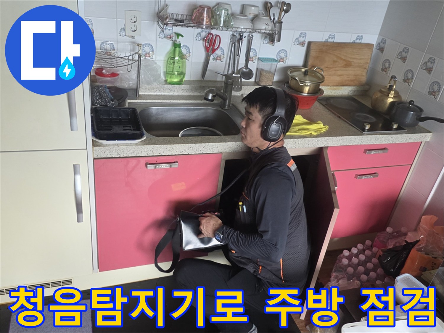 전문 엔지니어가 청음 탐지기를 착용하고 싱크대 하부 배관 상태를 확인하고 있습니다