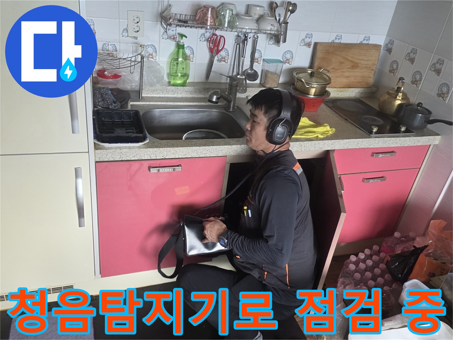주방 싱크대 하부에서 청음 탐지기를 사용하는 모습