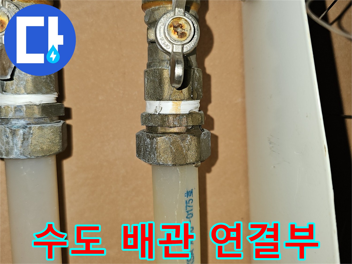 흰색 배관과 금속 밸브가 결합된 연결 부위 상세 사진