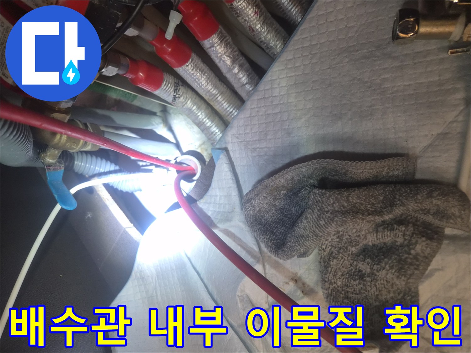 싱크대 하단 배관 틈새로 내시경 카메라를 넣어 상태를 파악하는 장면입니다.