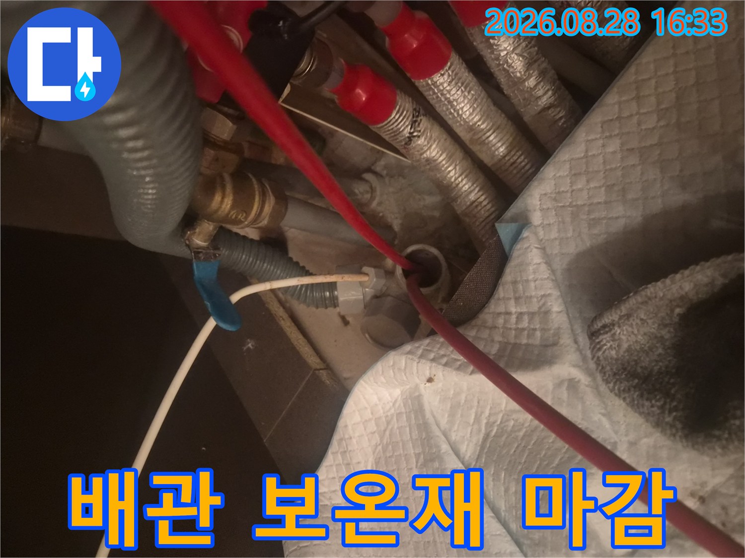 은색 보온재와 붉은색 마감이 적용된 배관의 모습입니다.