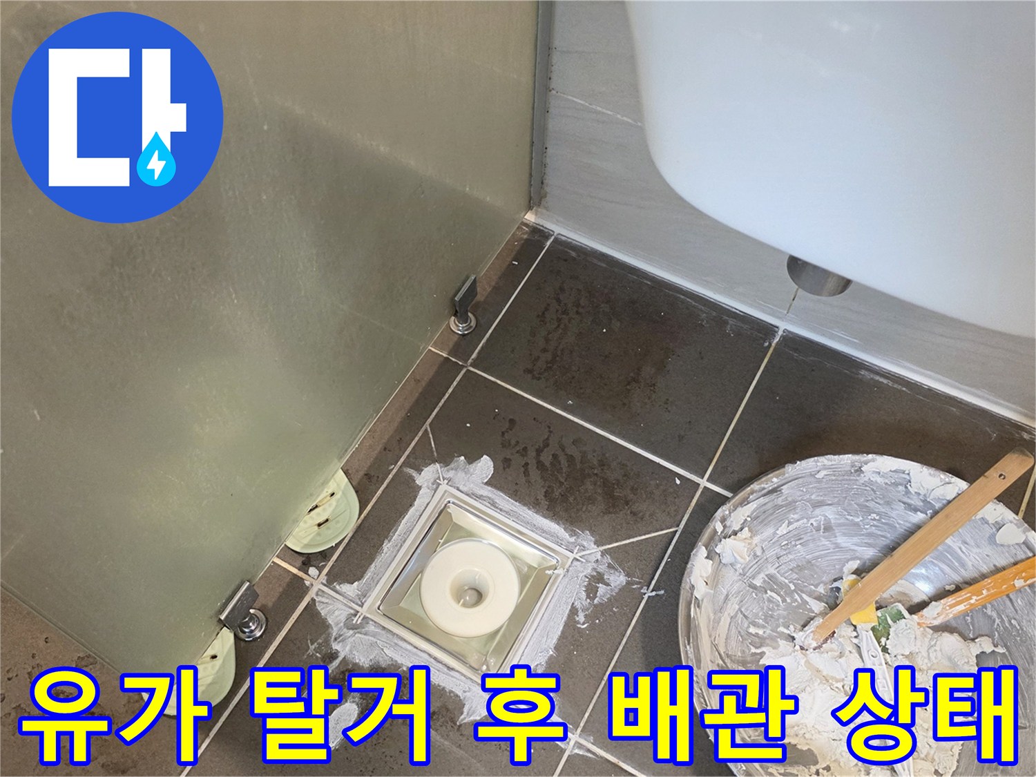 배수구 주변 타일 틈새와 배관 연결부 노출 사진