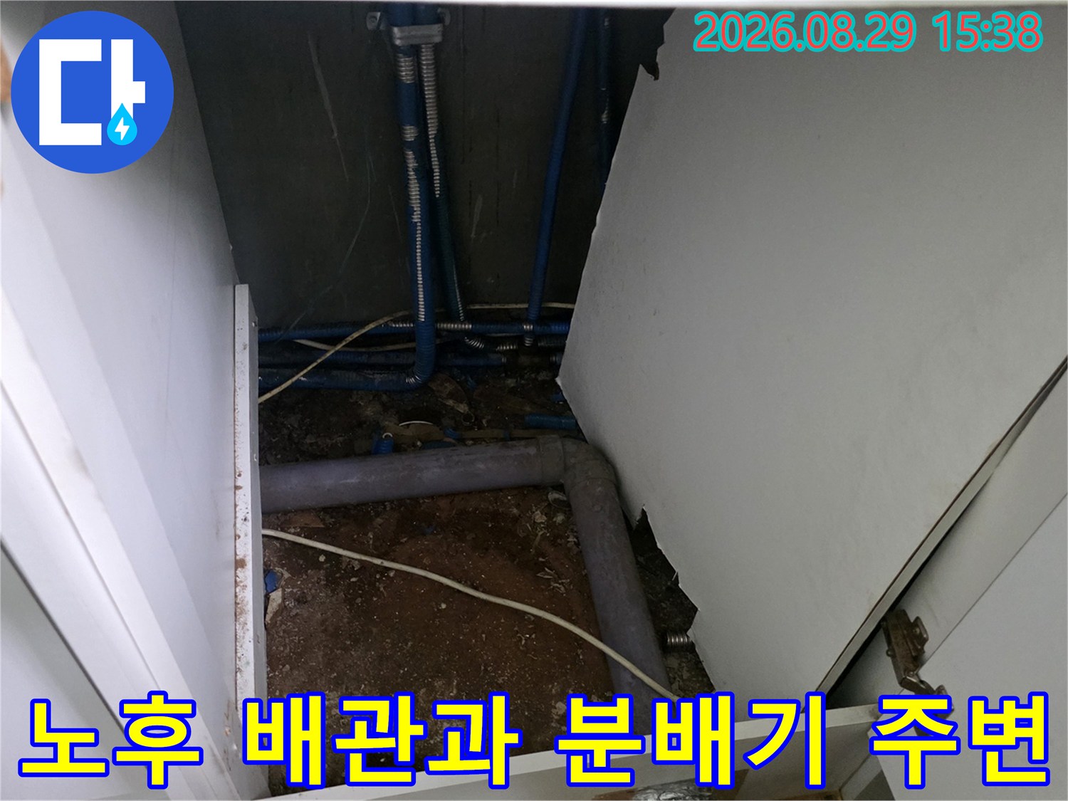 싱크대 아래 굴착 부위-노출된 파란색 배관과 노후된 연결 부위