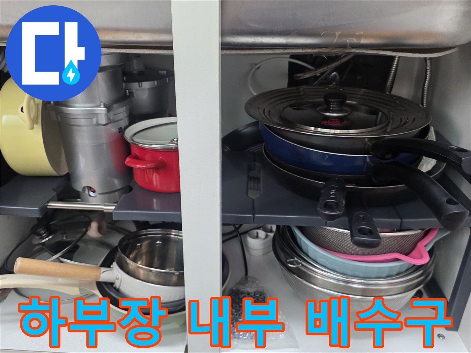 주방 하부장 내 냄비와 연결된 배수 호스 부위