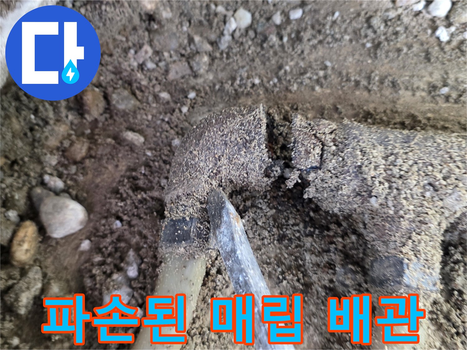 흙과 자갈 사이로 노출된 파손된 분배기 부위
