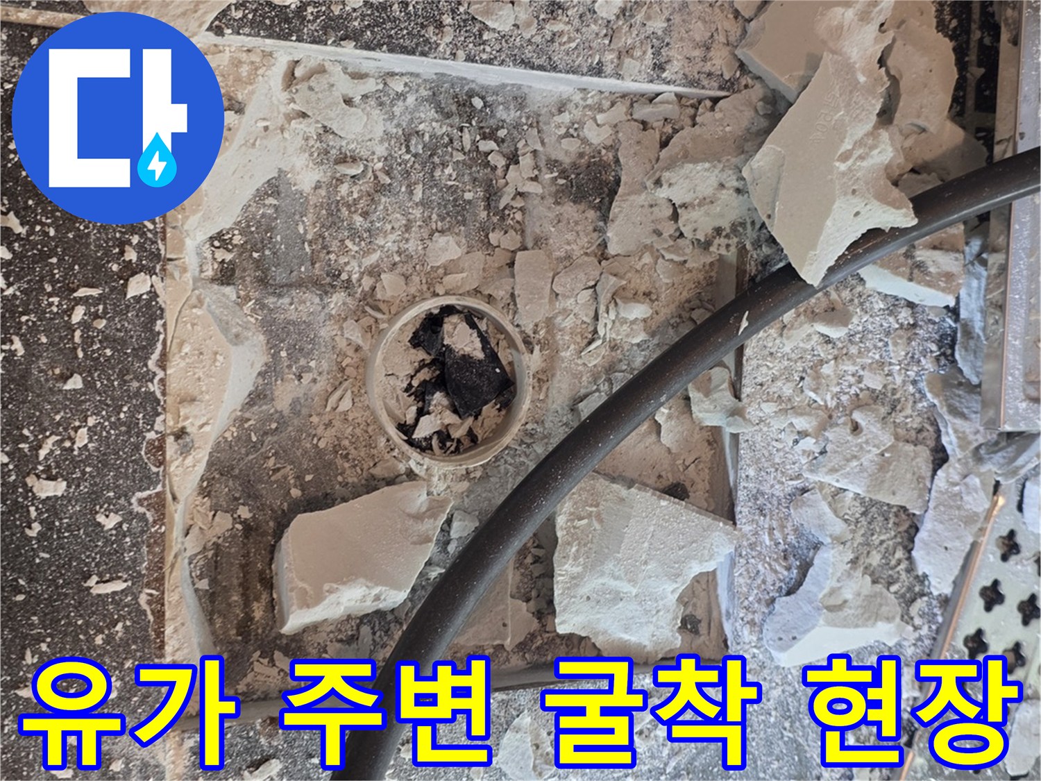 작업용-헤라와-파쇄된-타일-조각들이-보이는-배수구-주변-바닥