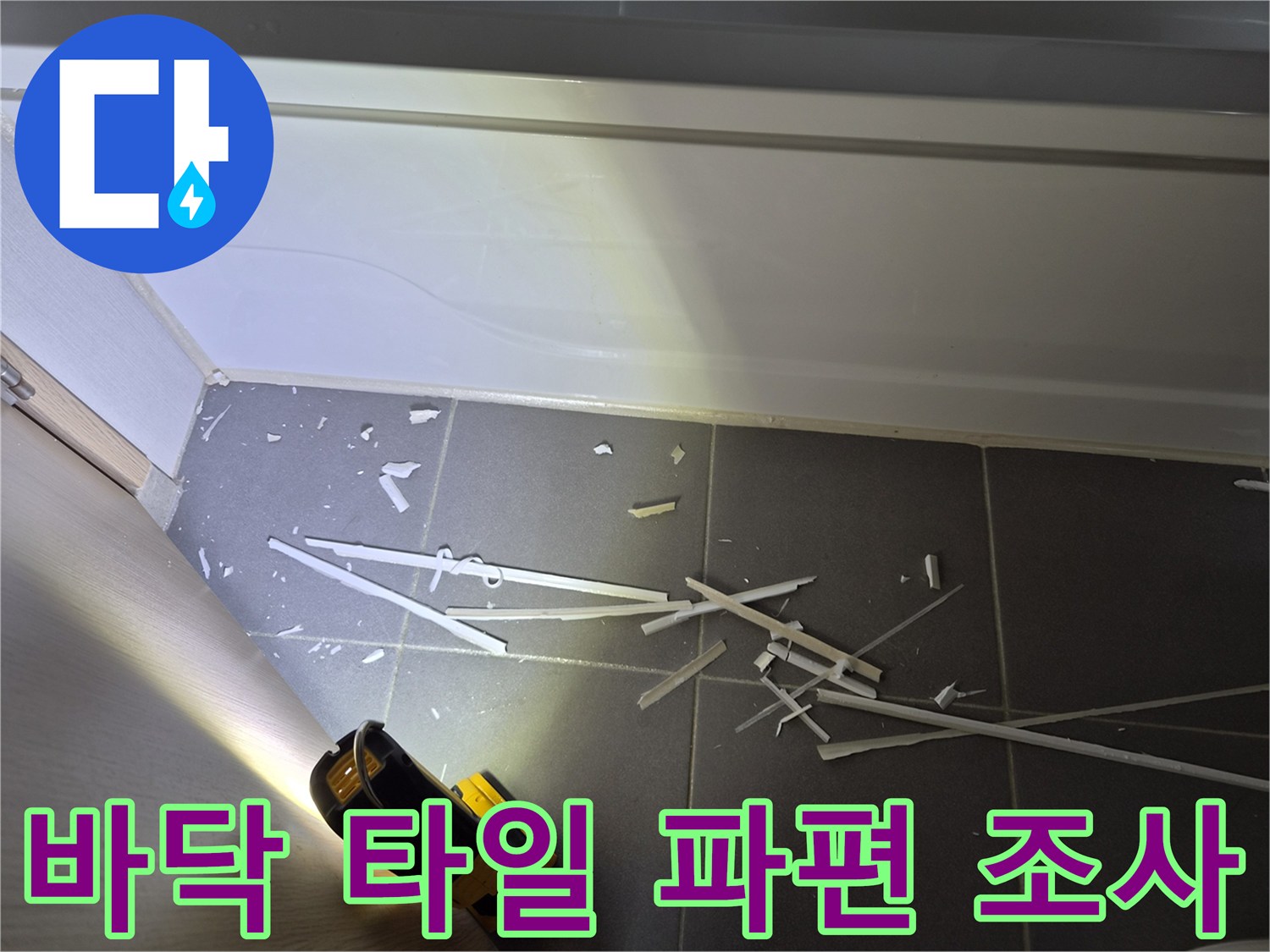 손전등으로 비춘-화장실 바닥의 흩어진 자재 조각들