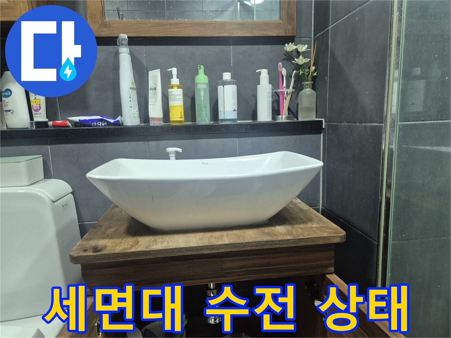 화장실 세면대 위쪽의 수전과 주변 선반 모습