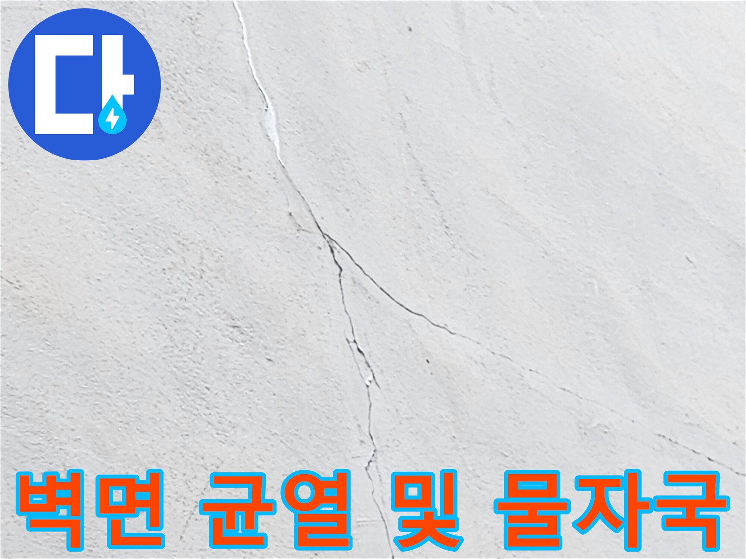 하얀색 벽면에 길게 나타난 균열과 수직 형태의 오염 흔적