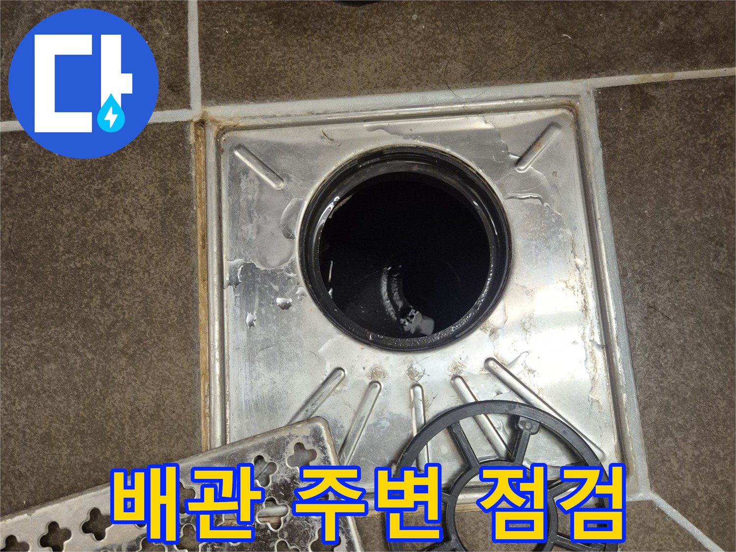 변기 탈거 후 노출된 배관 입구와 주변 타일의 상태입니다.