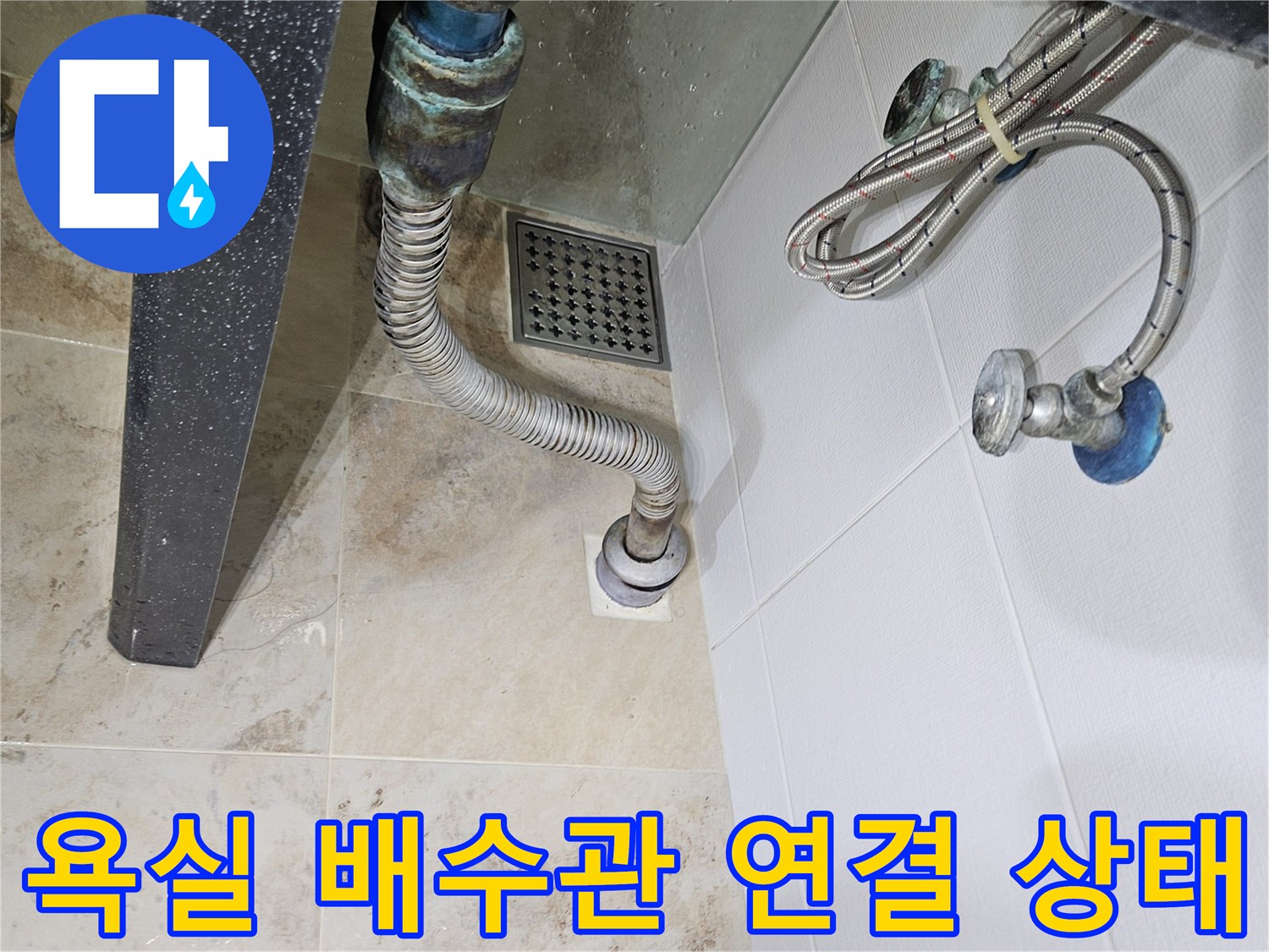 욕실 바닥 배수구와 연결된 금속 자재 배관의 모습