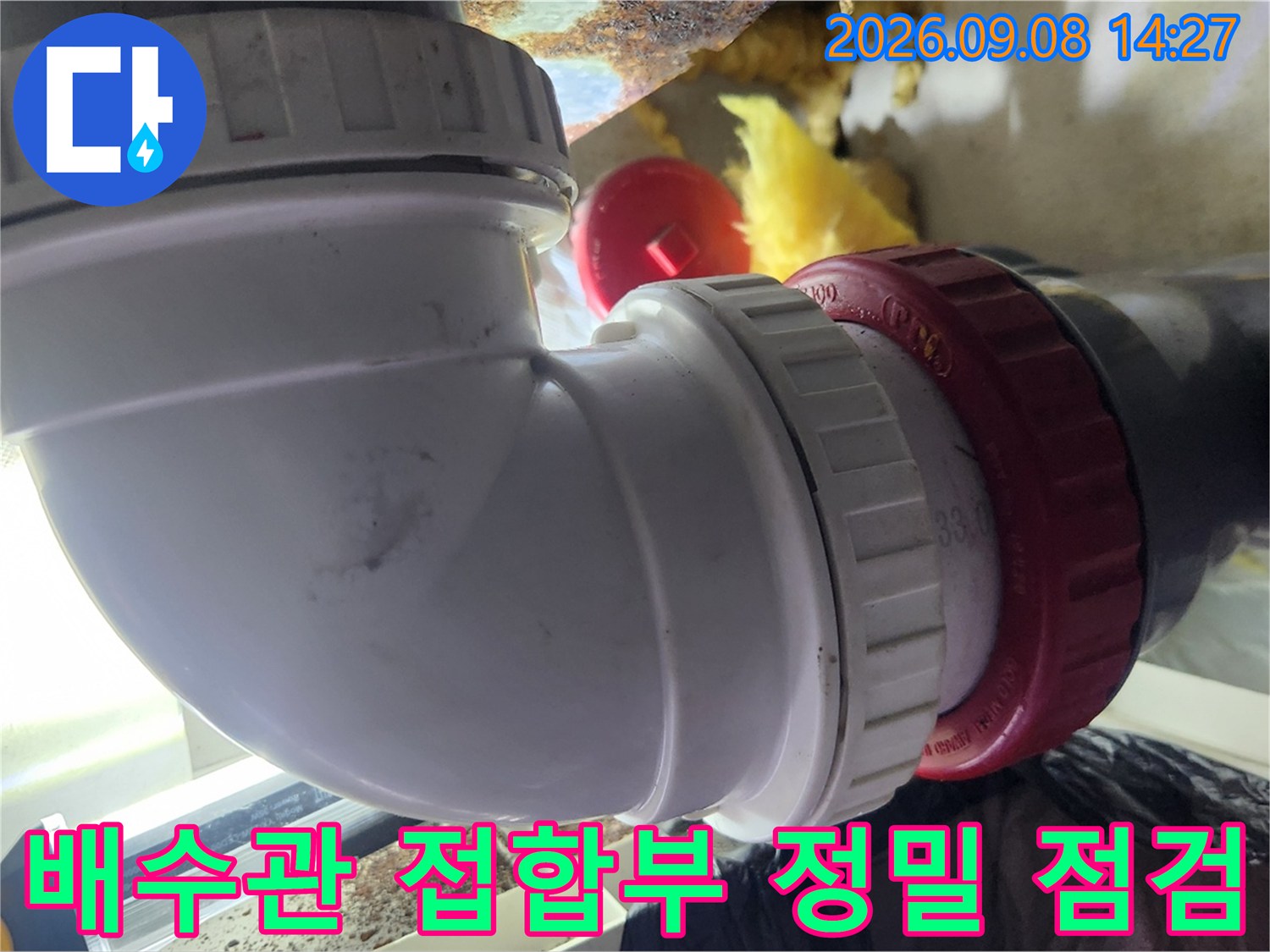 천장 배수관-흰색 엘보와 검은색 관의 연결 지점을 근접 촬영한 사진