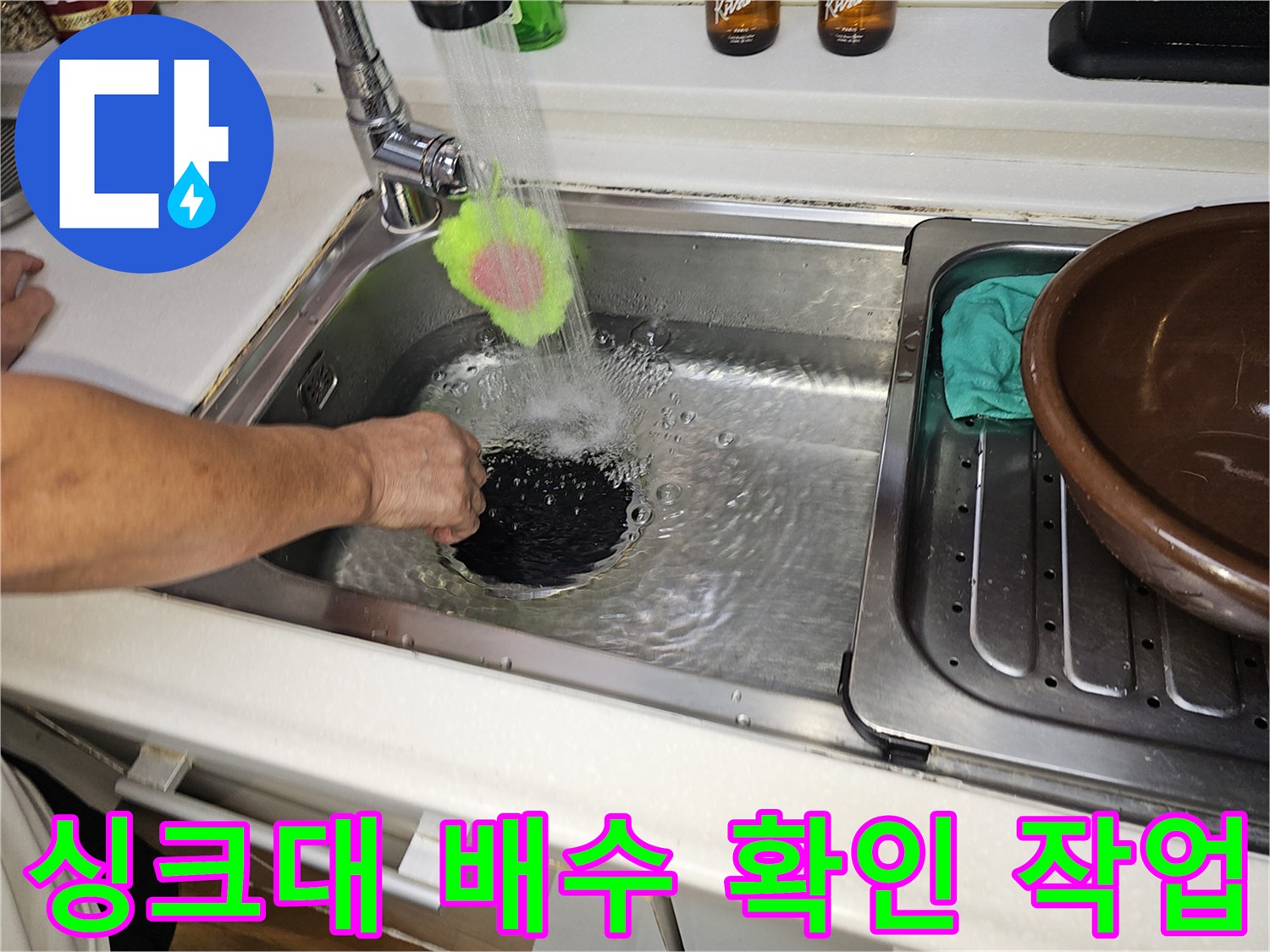 수전을 통해 물을 내려보내며 싱크대 하부 배수 상태를 점검 중입니다