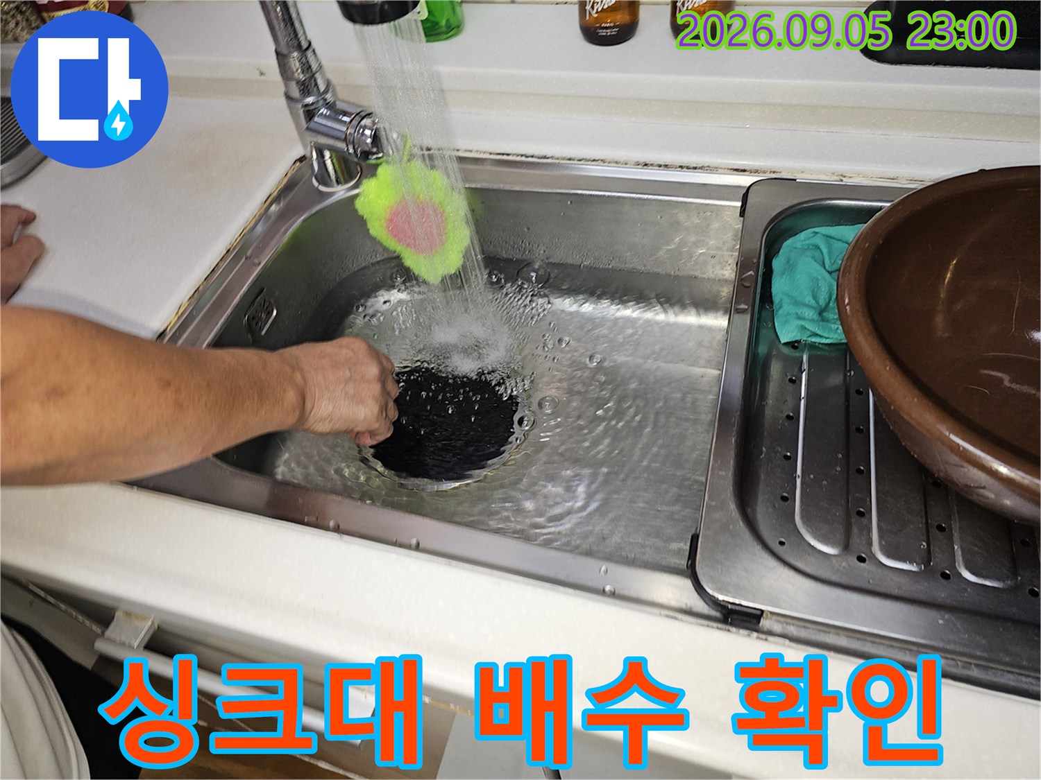 싱크대 수전에서 물이 나오는 장면-배수 상태 점검 중