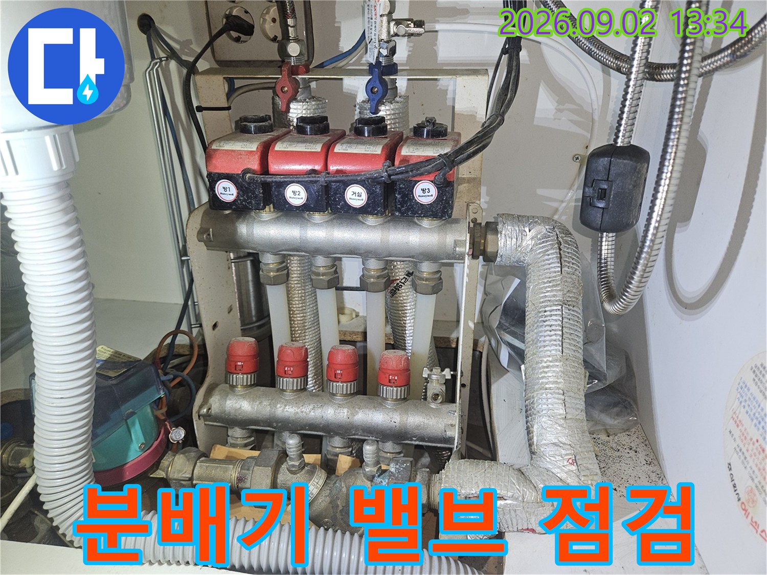 숫자가 적힌 분배기 밸브와 보온재가 감긴 배관의 근접 촬영 사진