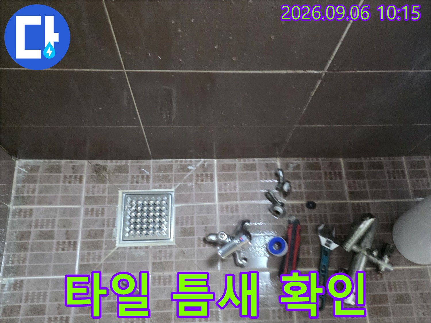물기가 보이는 화장실 타일 바닥과 배수구 주변 장비