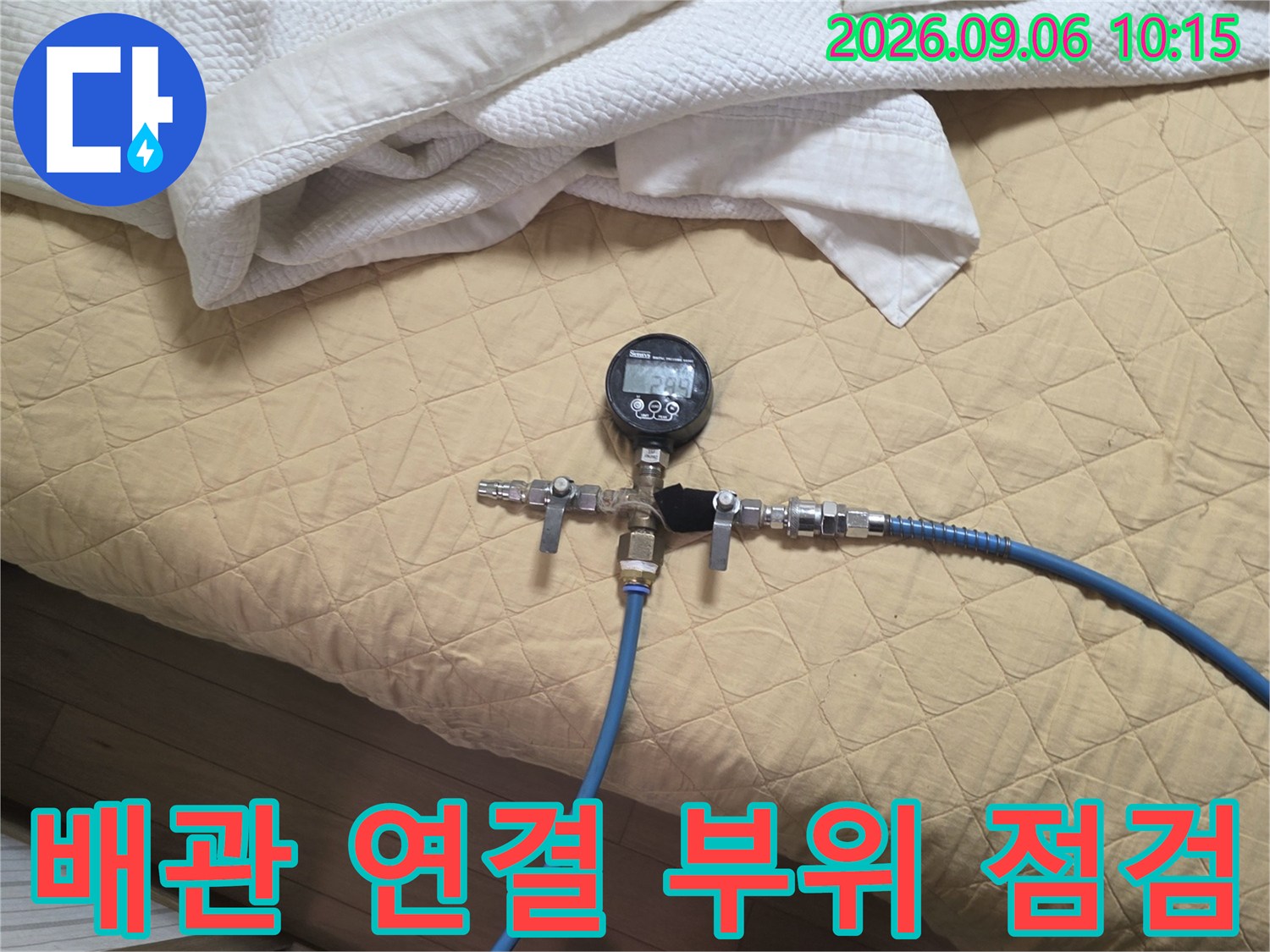 파란색 호스로 연결된 배관 압력 측정 장치-누수 진단 과정