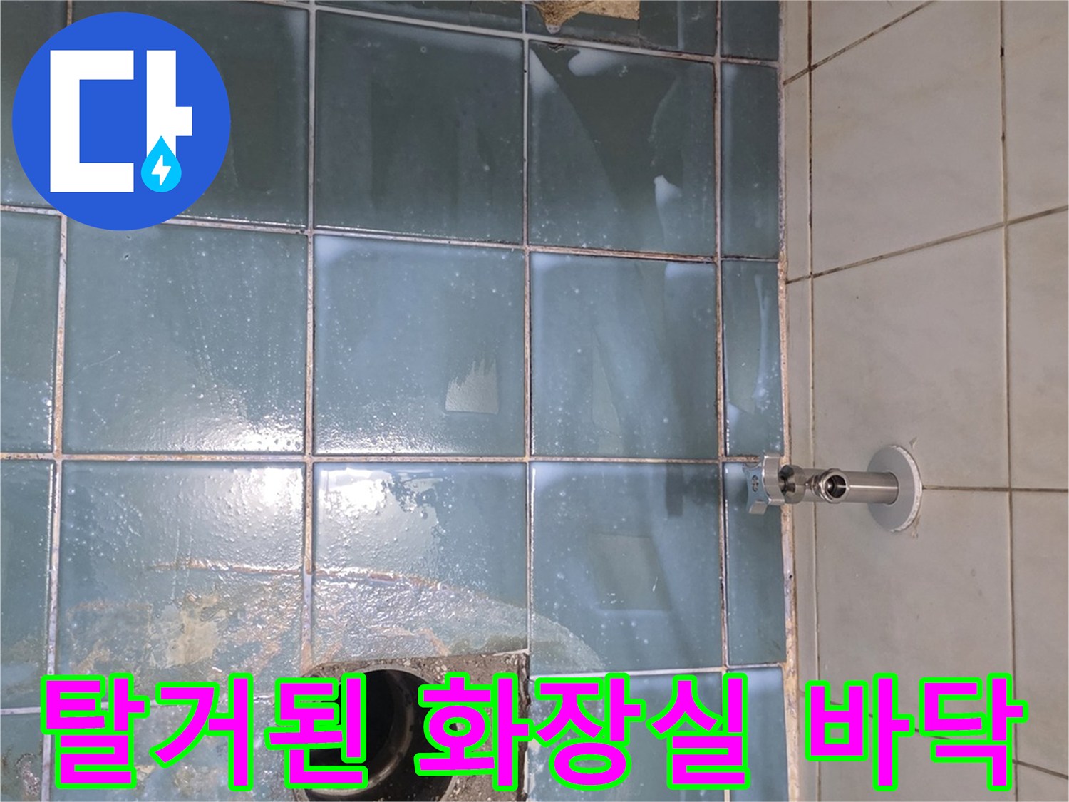 위생기구 제거 후 드러난 파란 타일과 배수구 관로