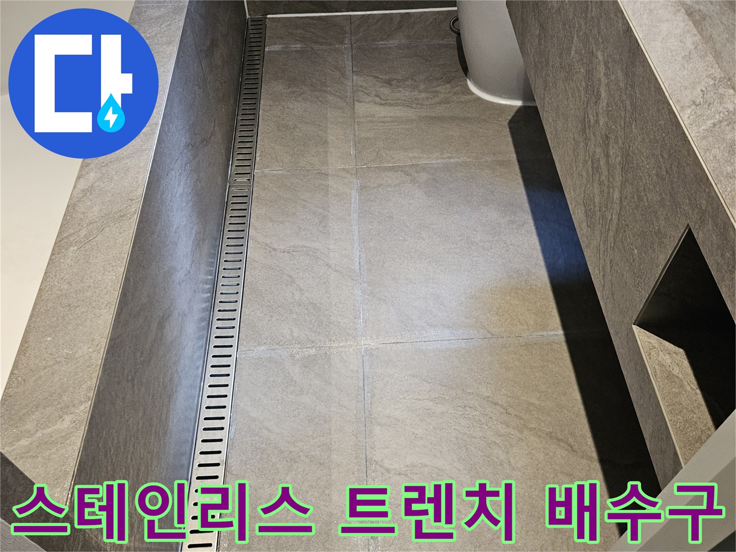 매끄러운 대리석 타일과 금속제 트렌치 배수구의 접합부