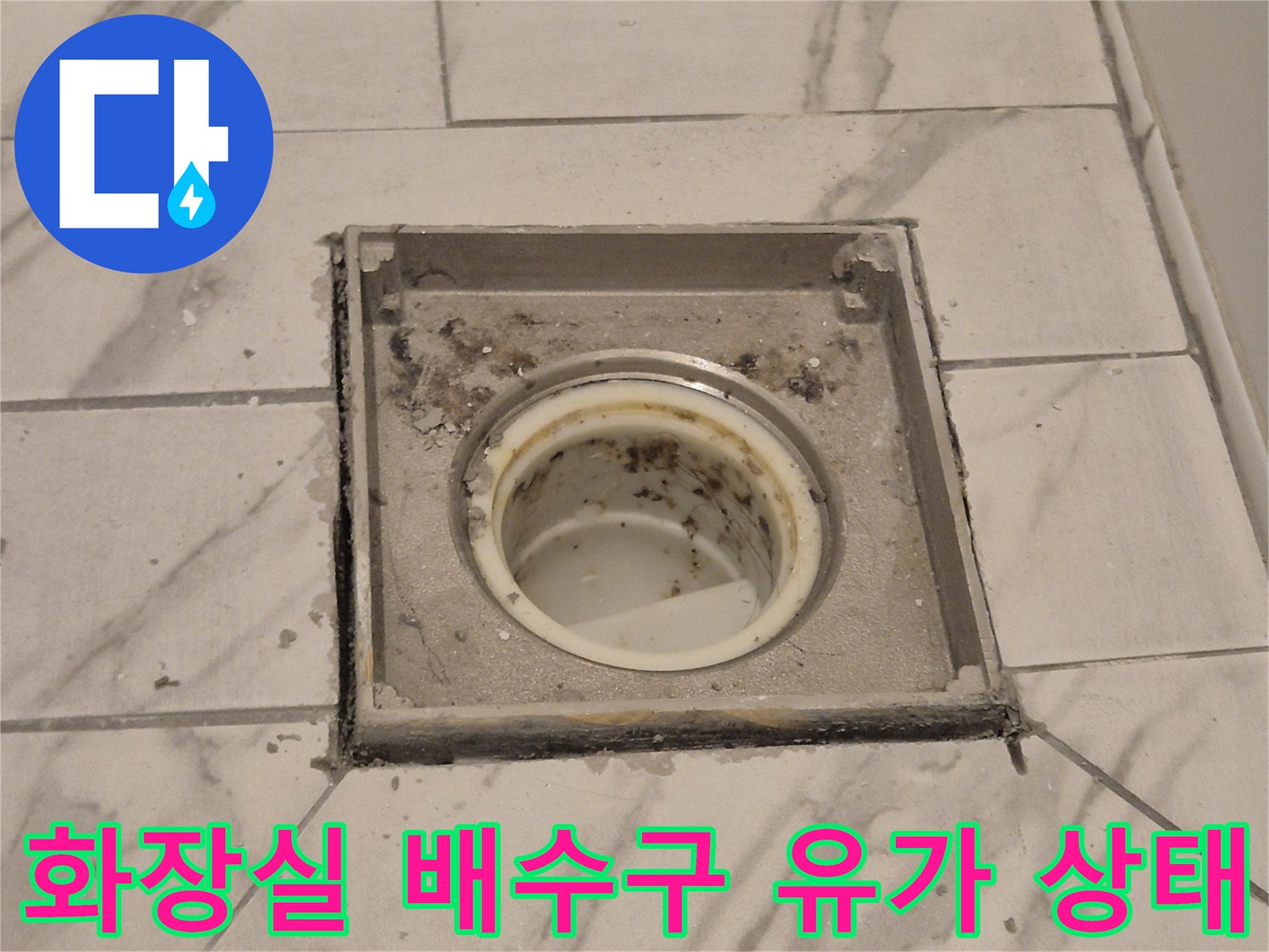 배수구 주변의 타일 균열과 오염된 상태를 나타내는 사진입니다.