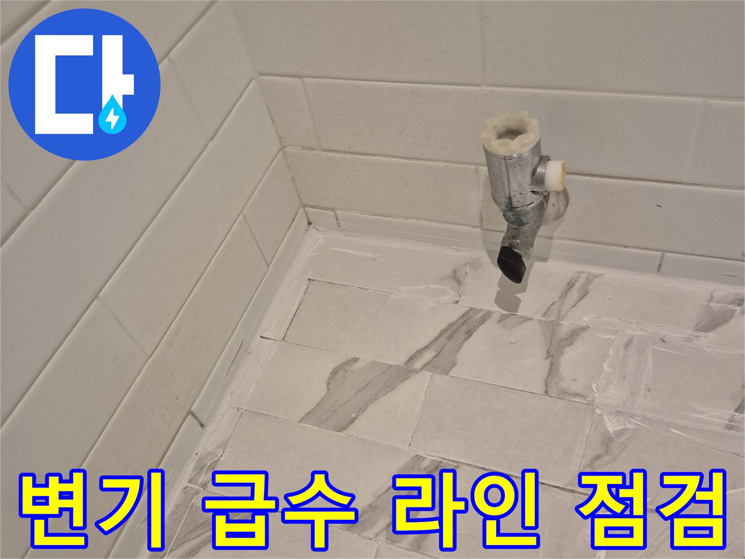 타일 벽면의 수도 밸브와 배관 연결 부위 상세 사진