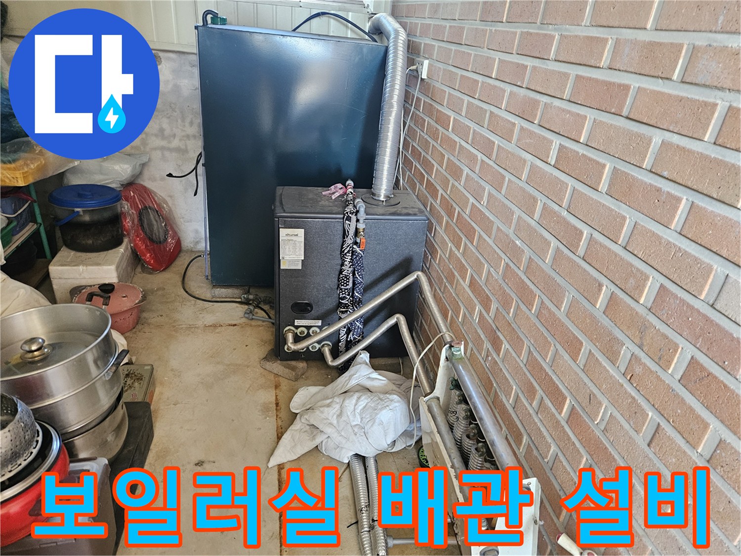 벽돌 벽 옆 보일러와 연결된 금속 배관 시설물