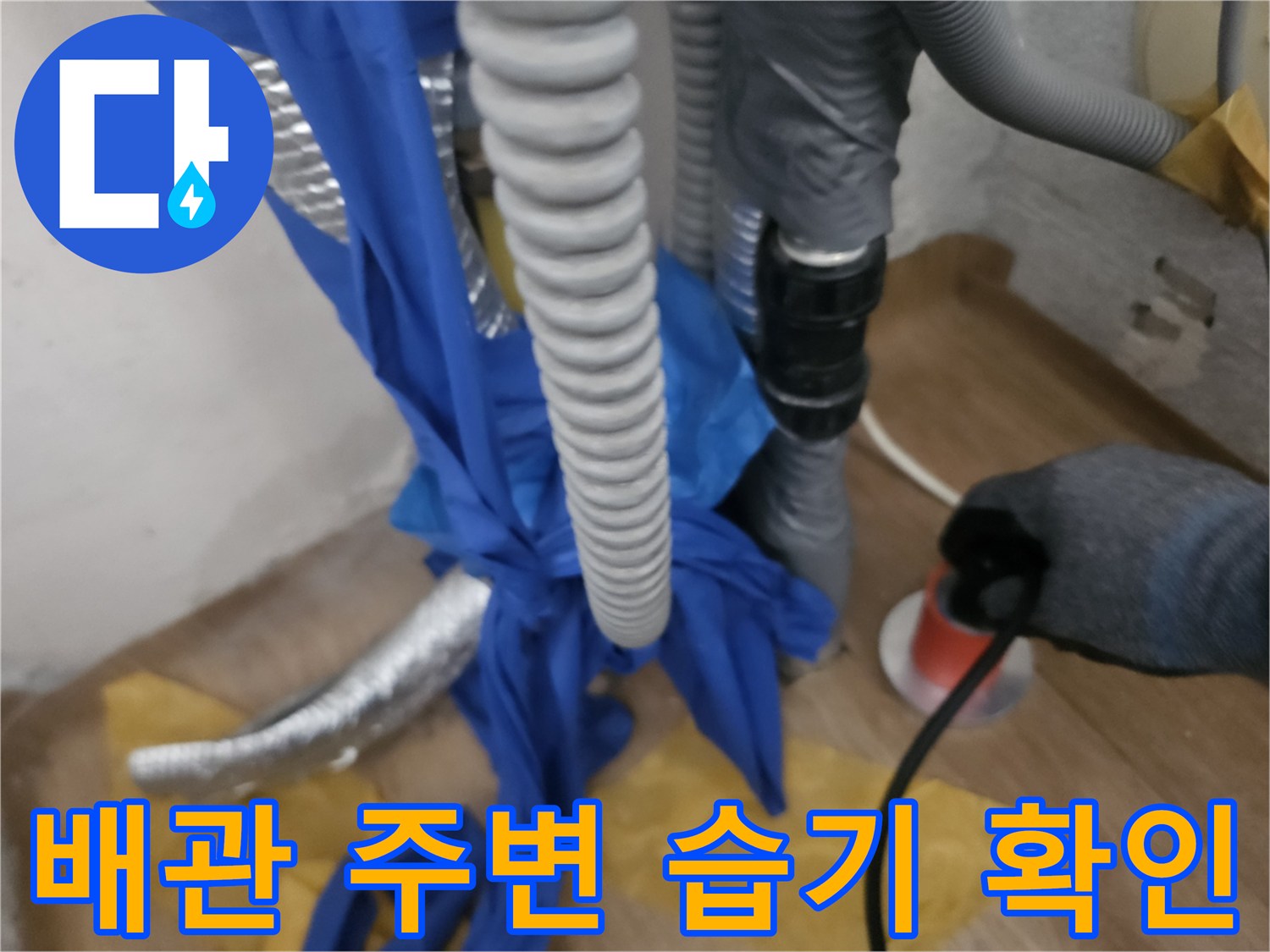 보일러 하단 - 배관 누수 여부를 확인하는 작업자 손길