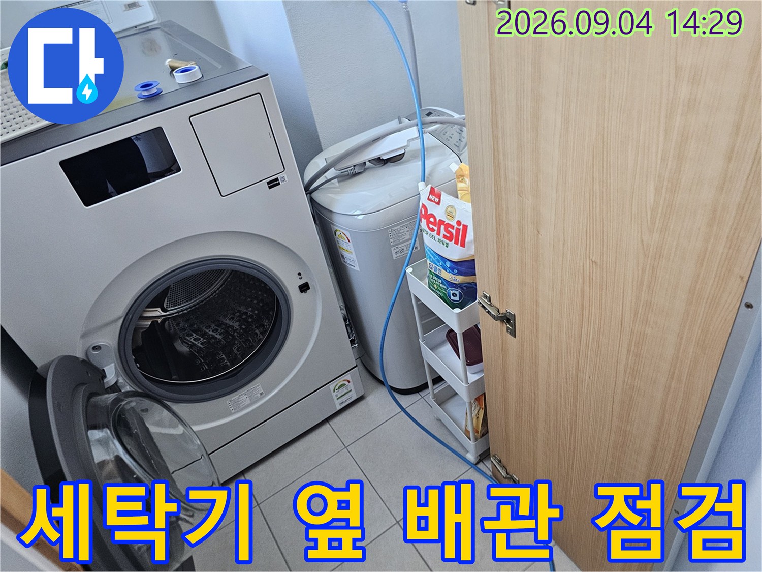 세탁기와 세제 선반이 있는 세탁실 내부 사진입니다.