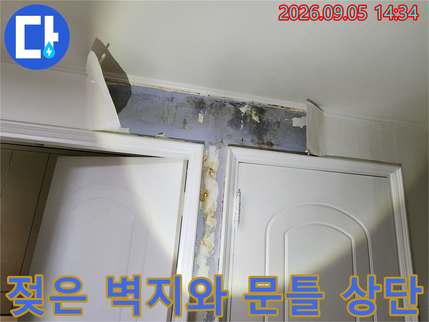 누수 피해로 인해 젖고 들뜬 문틀 상단 벽지 모습입니다.