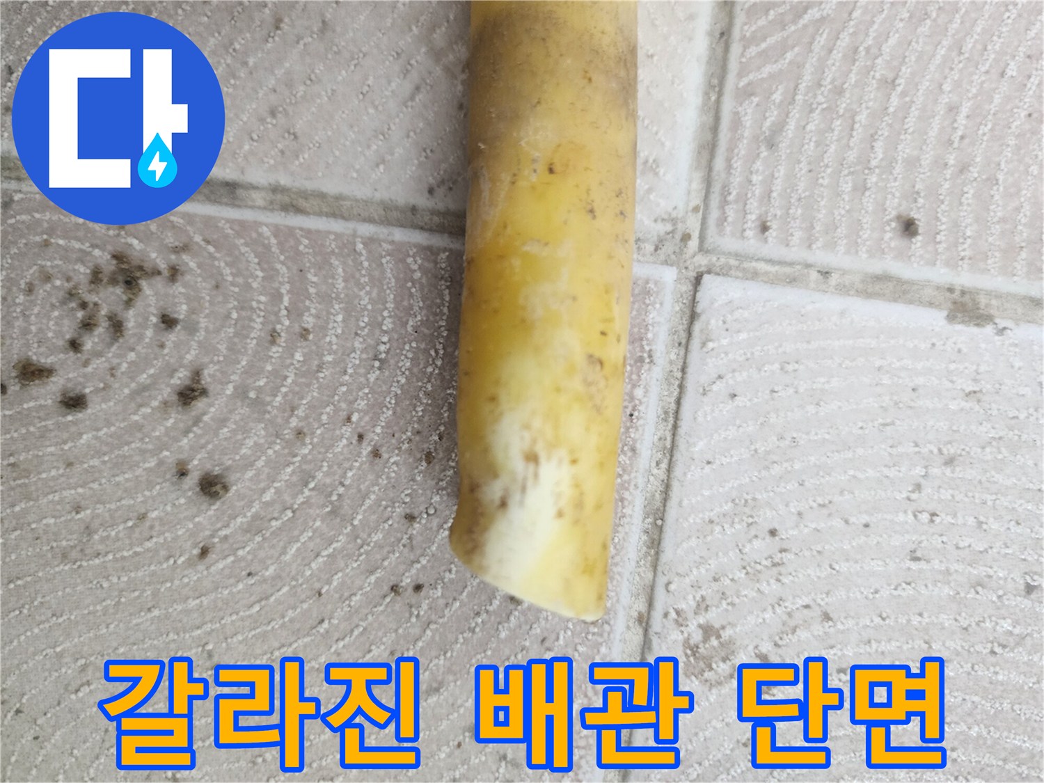균열이 발생하여 물이 새어 나오고 있는 노란색 매립 배관의 모습입니다.