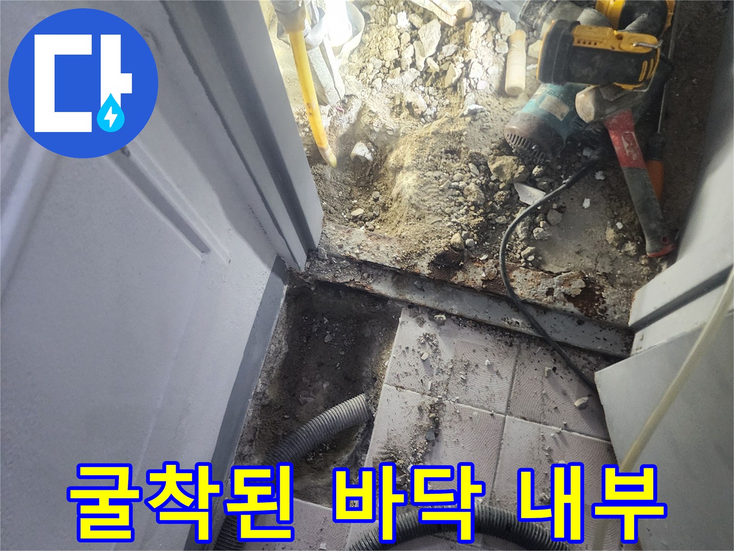 바닥을 파내어 드러난 배관과 작업 도구들이 놓여 있습니다.